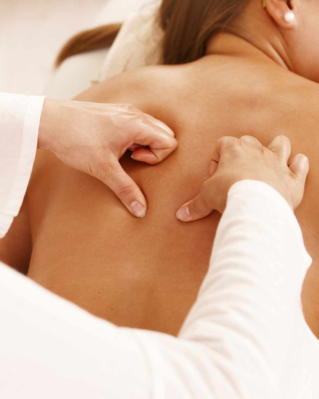 Performing back massage on client.