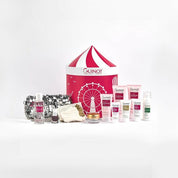 Collection of Guinot skincare products and a red and white striped bag on a white background