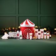 Guinot skincare products and a festive box on a green background with decorative lights.