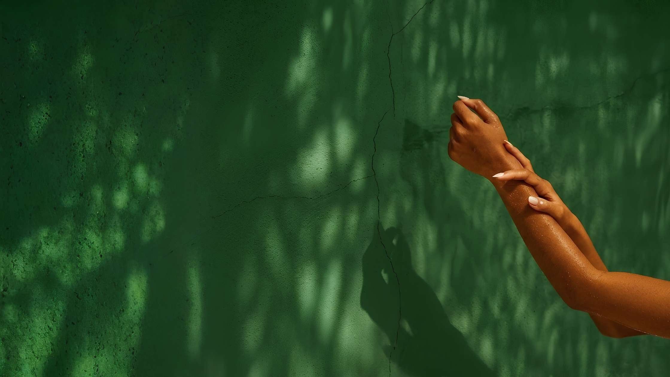 A woman's arms stretched out against a green background