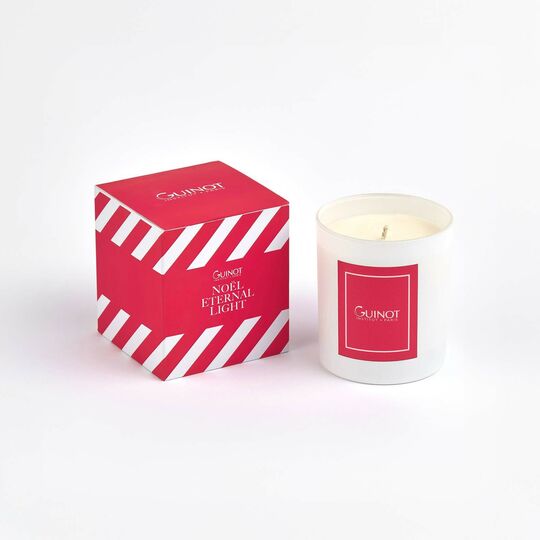 White candle with red label and matching box on a white background, featuring the brand 'Quinot'.