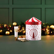 Cosmetic product and 'NOEL GOLDEN AGE' box with festive decorations on a green background