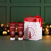 Two Guinot skincare products with a decorative box on a green background with festive decorations.