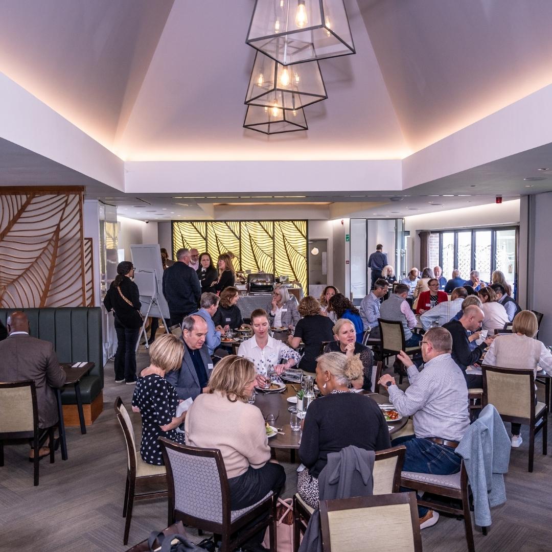 People dining in a modern restaurant with large windows and stylish decor.