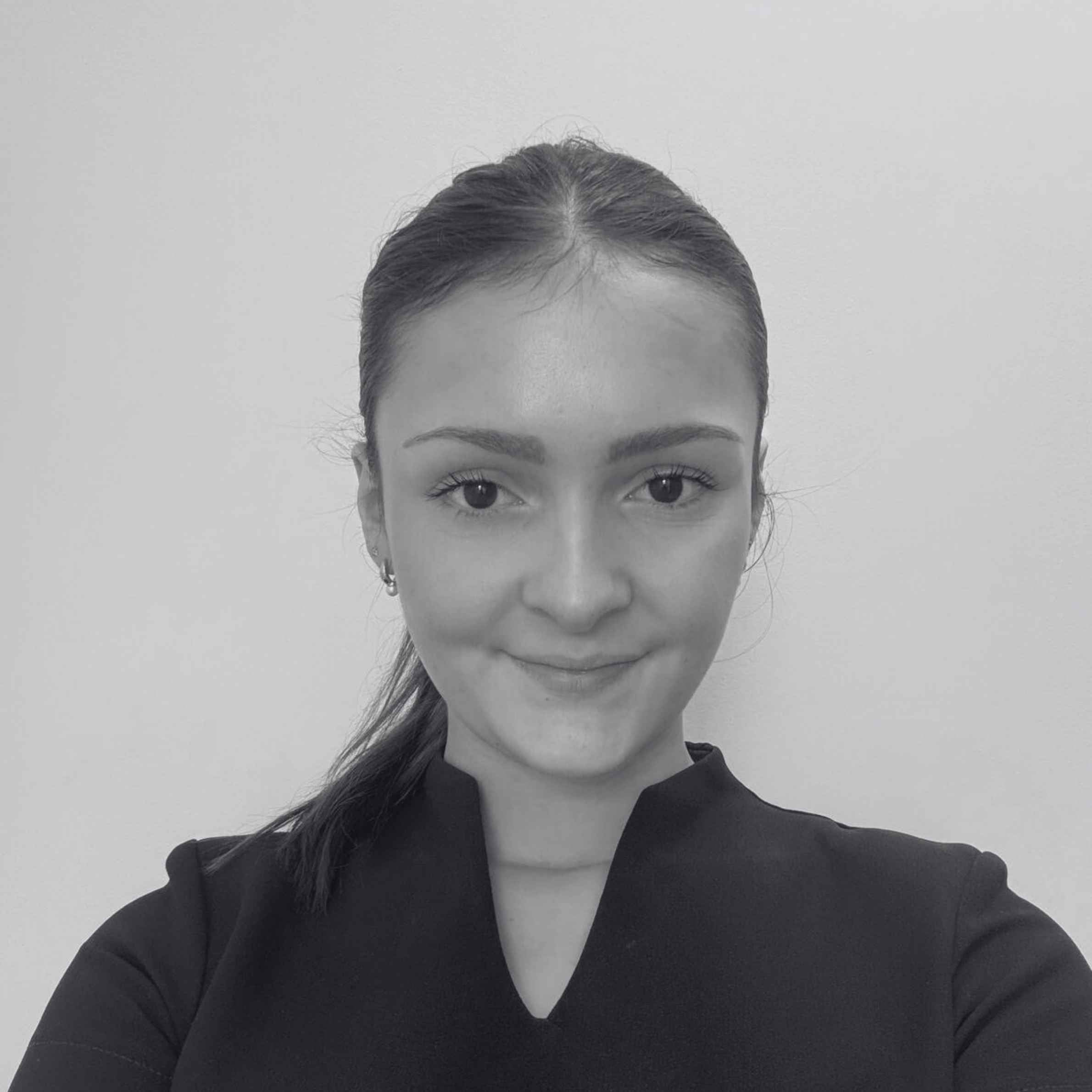 Black and white portrait of a person with a neutral expression on a plain background