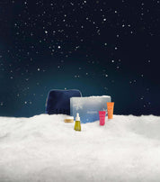 Cosmetic set with Elemis branding on a snowy landscape at night.