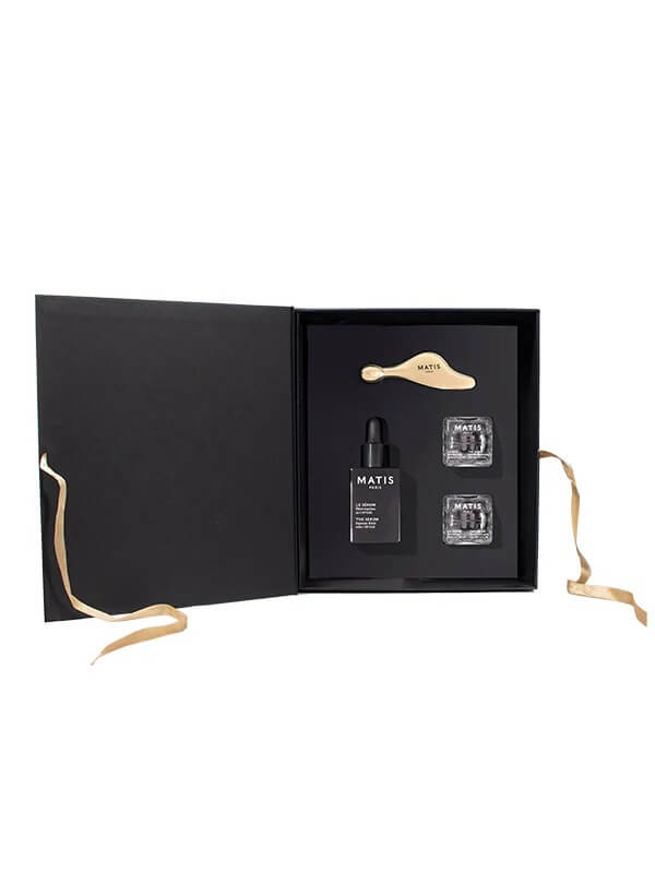 Set of skincare products in a black box with gold accents on a white background