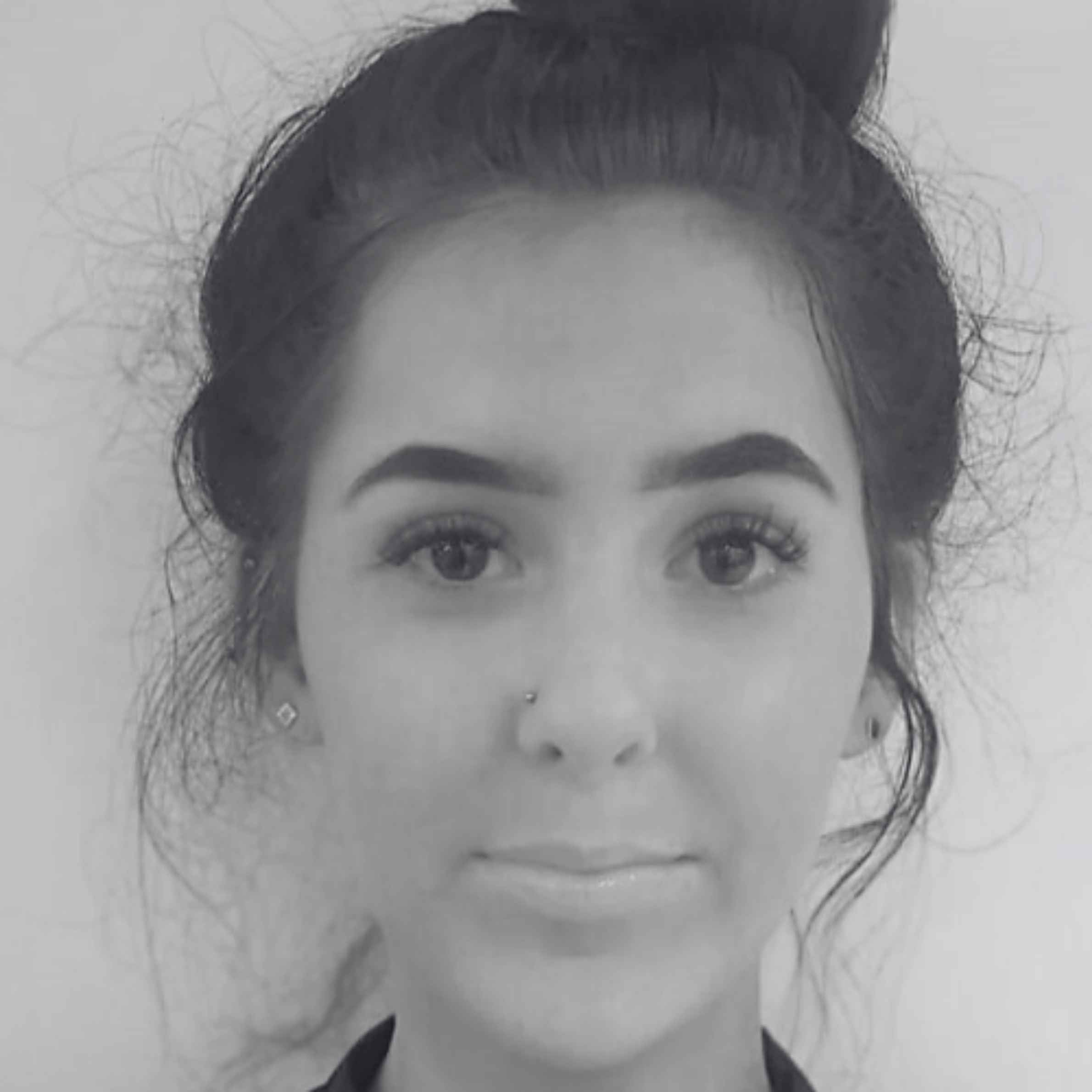 Black and white photo of a person with hair styled in a bun.